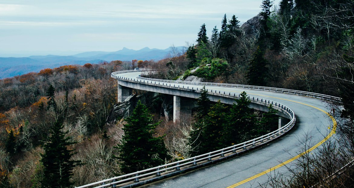 Blue Ridge Parkway viaduct curving around a forested mountainside in North Carolina