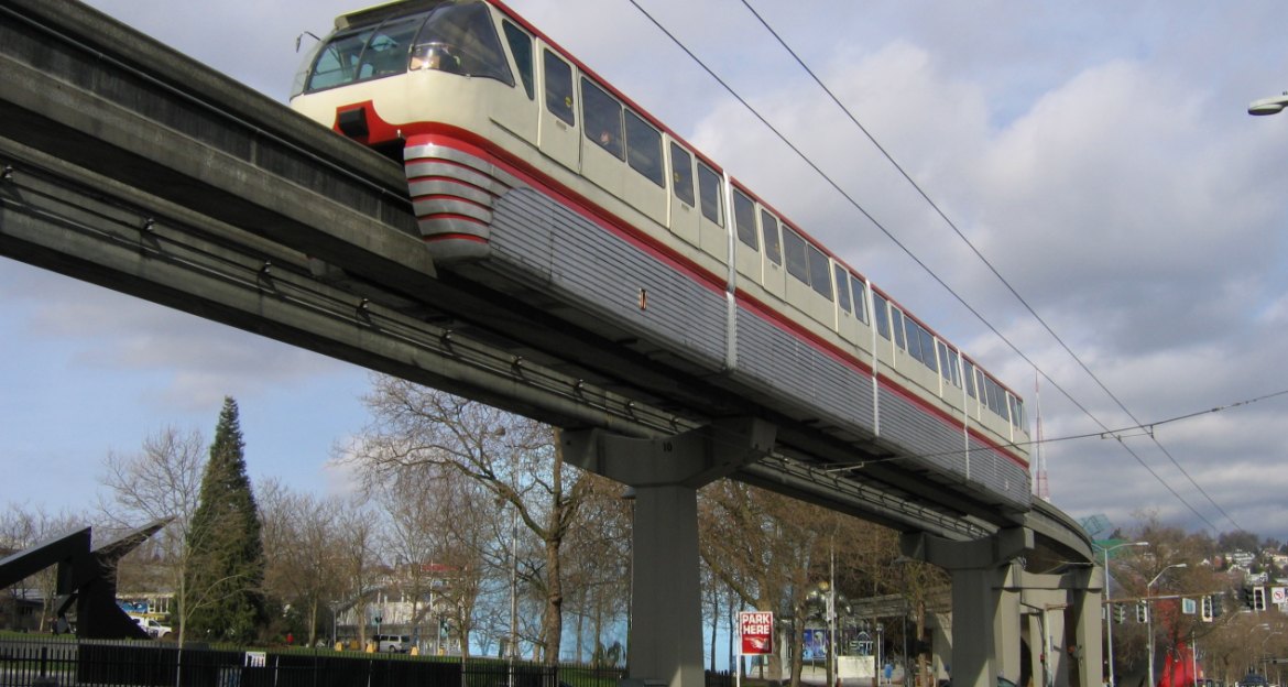 Seattle Center Monorail train gliding along its elevated concrete track