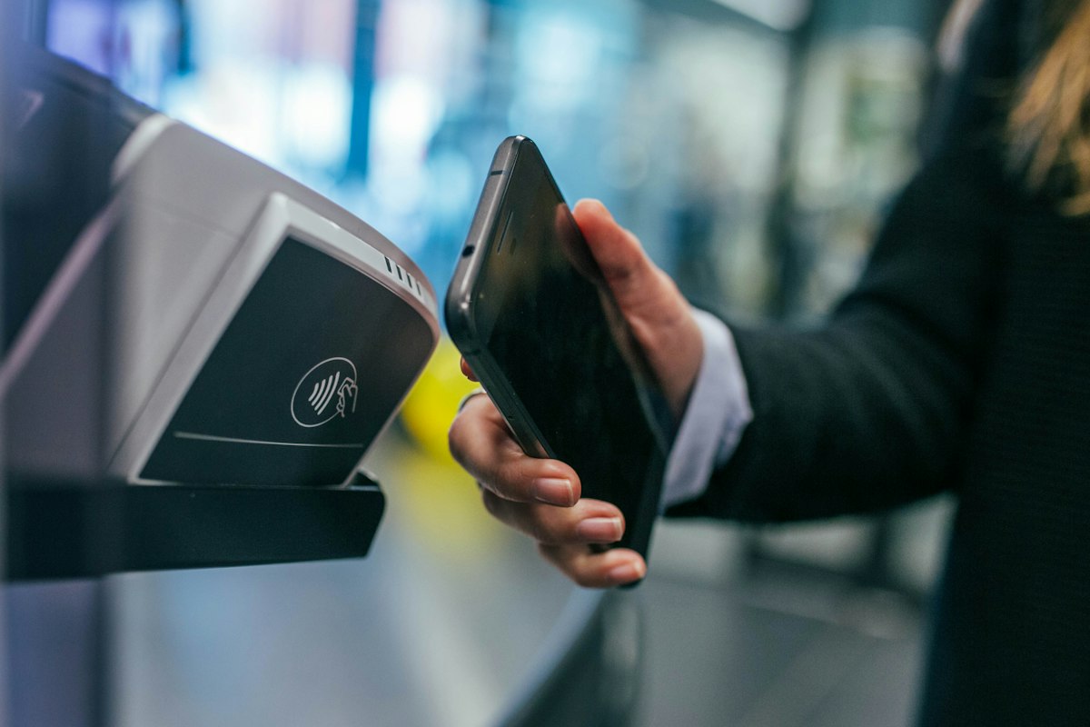Fan tapping a smartphone mobile ticket on a scanner at the entry gate