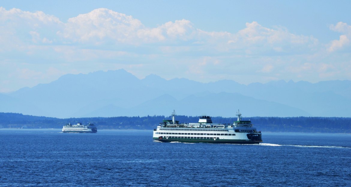 Washington State ferry crossing blue Puget Sound with the Olympic Mountains in the distance